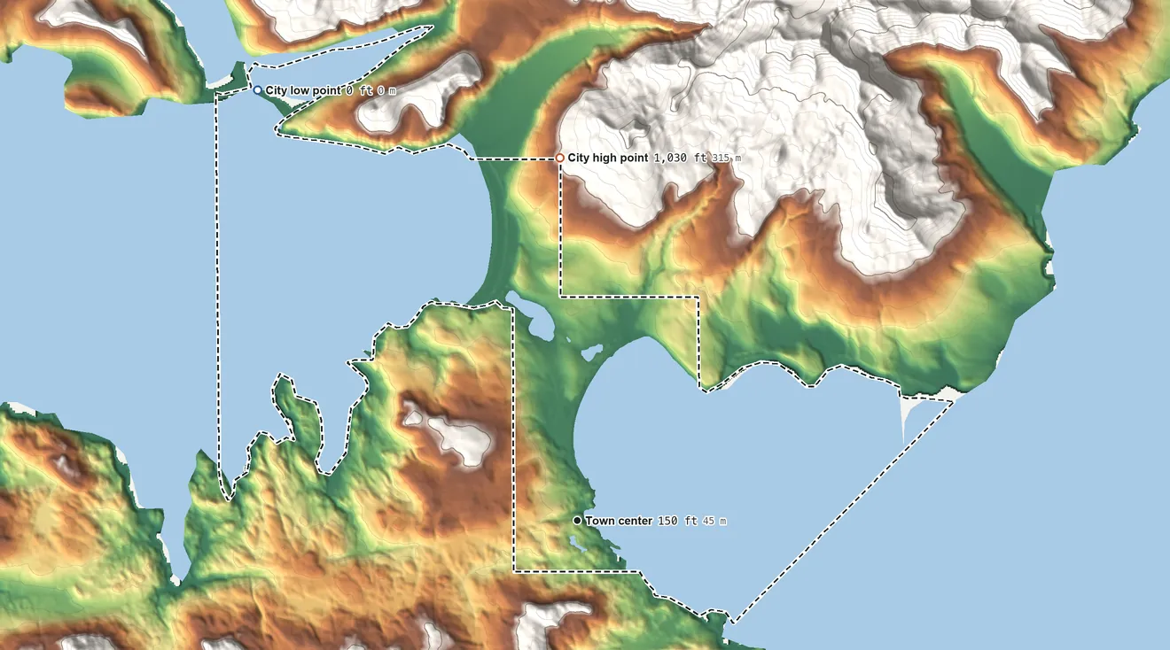 Topographic elevation map of Atka, Alaska, shaded from sea level level on Korovin Bay to 1,030 ft on the north edge, below higher ground just outside
