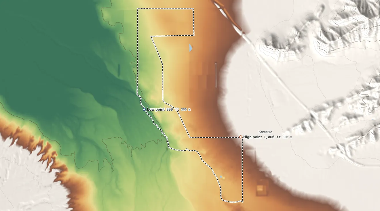 Topographic elevation map of St. Johns, Maricopa County, Arizona, shaded from 990 ft on the northwest side to 1,060 ft at the foot of the Ma Ha Tuak Range
