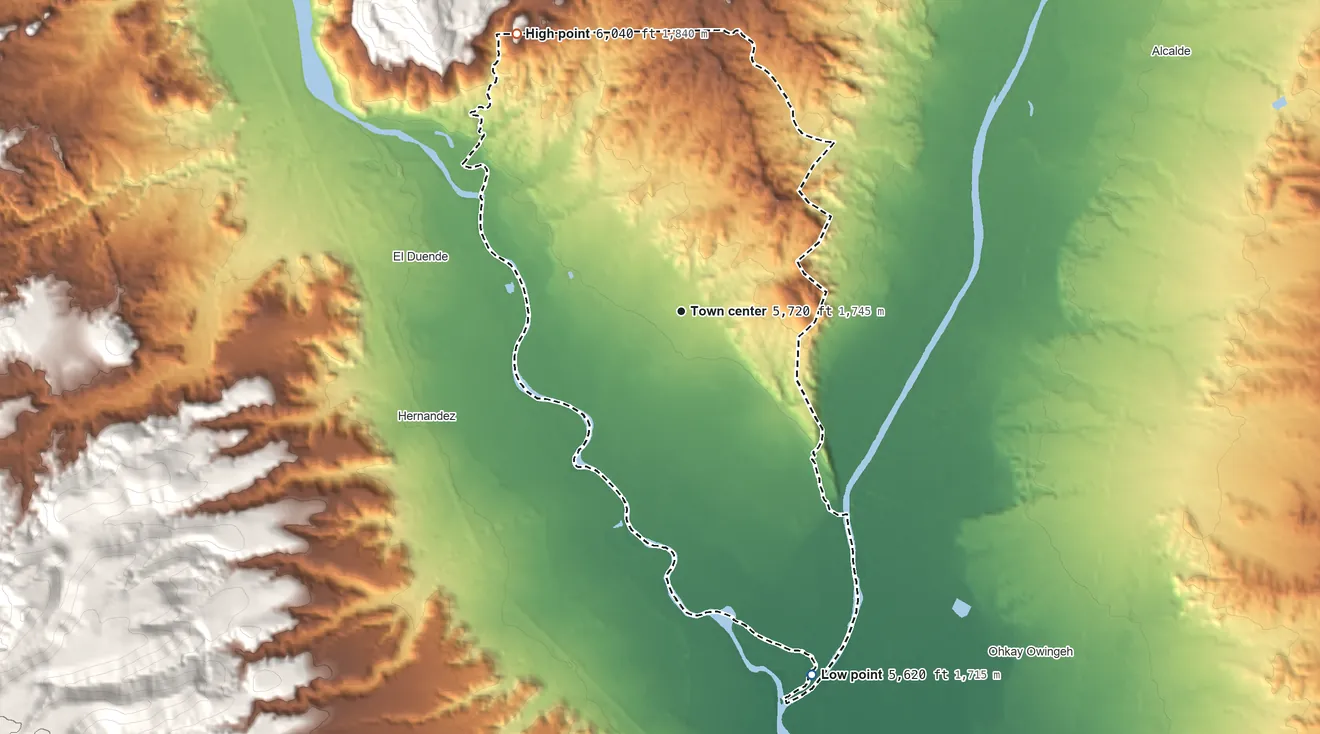 Topographic elevation map of Chamita, New Mexico, shaded from 5,620 ft on the south side to 6,040 ft on the northwest edge, below higher ground just outside