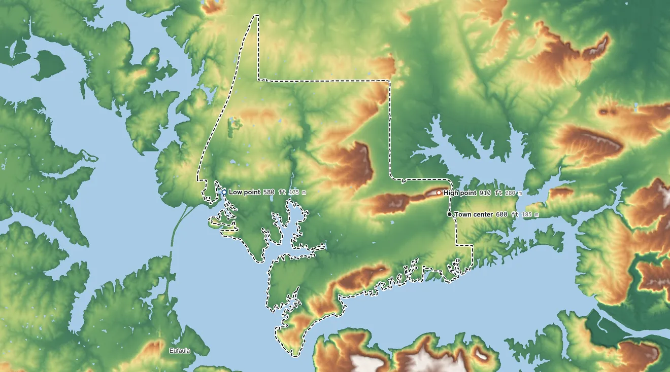 Topographic elevation map of Texanna, Oklahoma, shaded from 580 ft on the west side to 910 ft on Texanna Mountain
